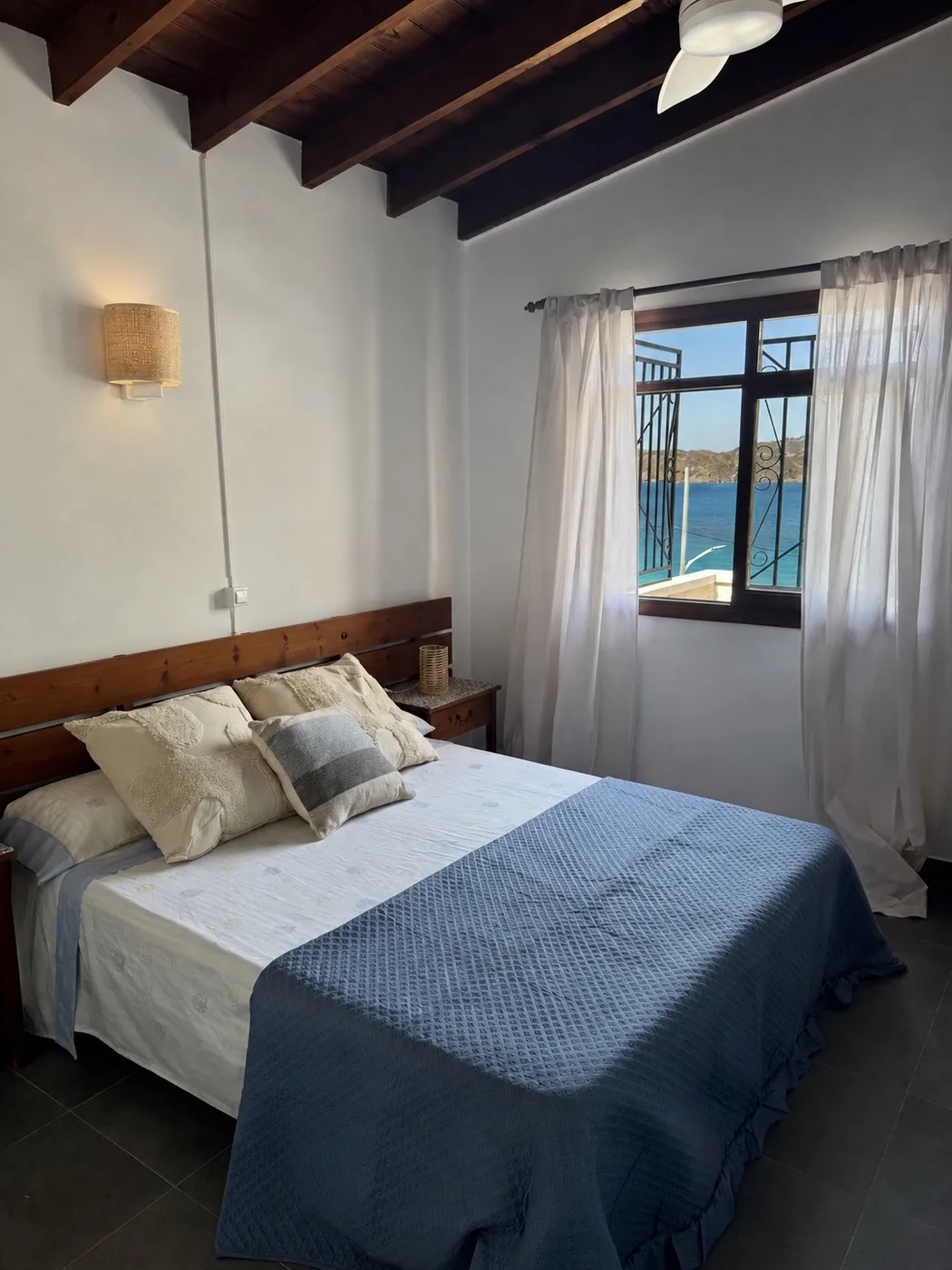 Dormitorio de Casa Mariana con cama de matrimonio y ventana con vistas al mar