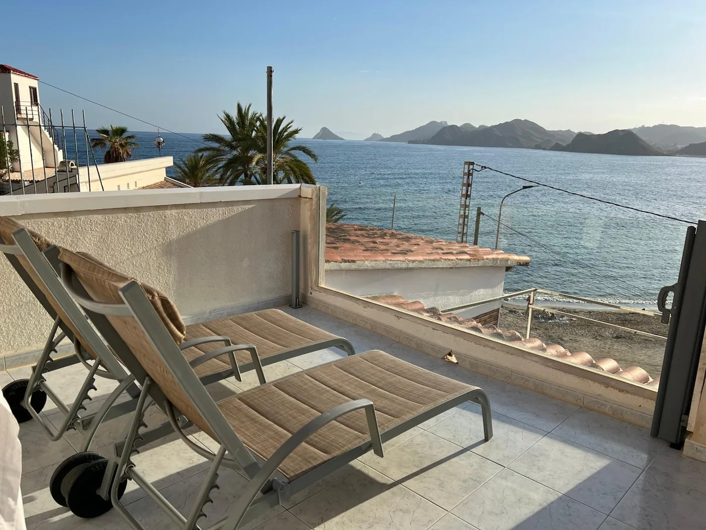 Terraza de Casa Mariana con tumbonas y vistas a la bahía de Calabardina