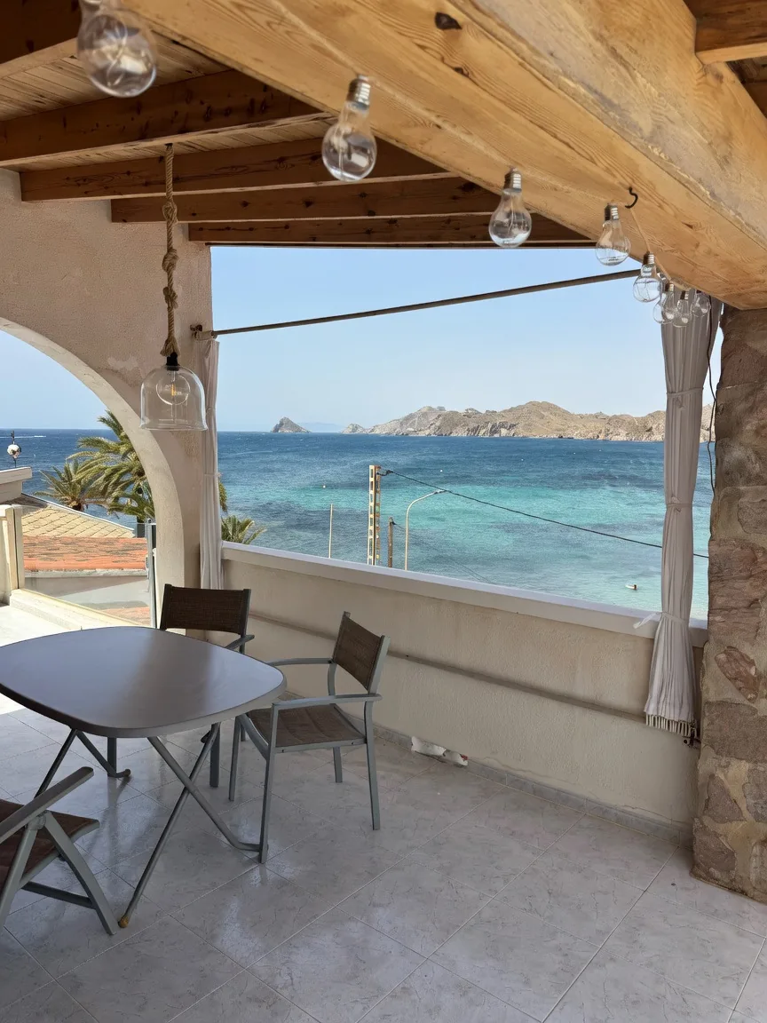 Terraza de Casa Mariana con mesa y vistas al mar turquesa de Calabardina